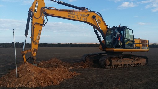 A worker operating machniery to dig into the ground.
