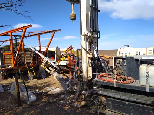 A worker operating drilling equipment to extract soil, rock and underground water for testing.