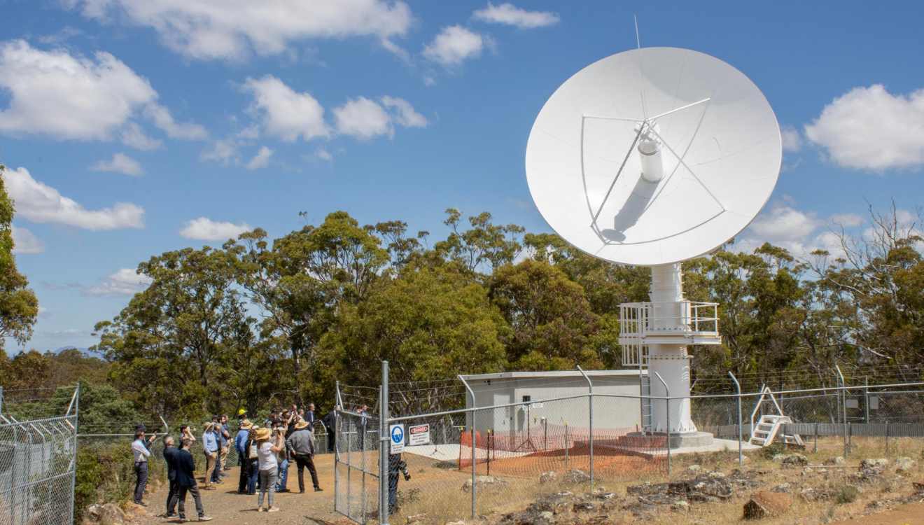 The opening day of the UTAS antenna - a group of people taking pictures of the antenna on a sunny day.