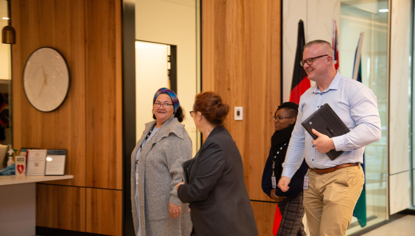 Image depicting the diverse employees that work at our department as they enter through our building in the foyer.