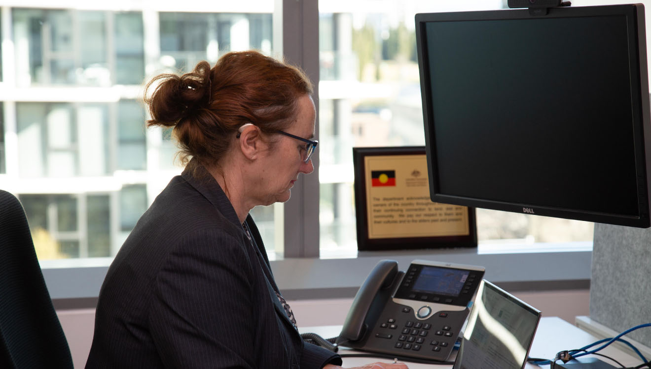 Image depicting our flexible workplace with an employee using assistive technology at their desk.
