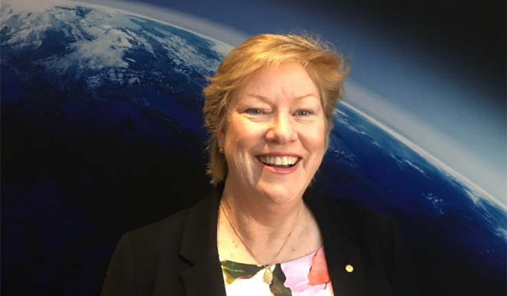Image of Dr Clark in front of a picture of Earth Image of Dr Clark in front of a picture of Earth