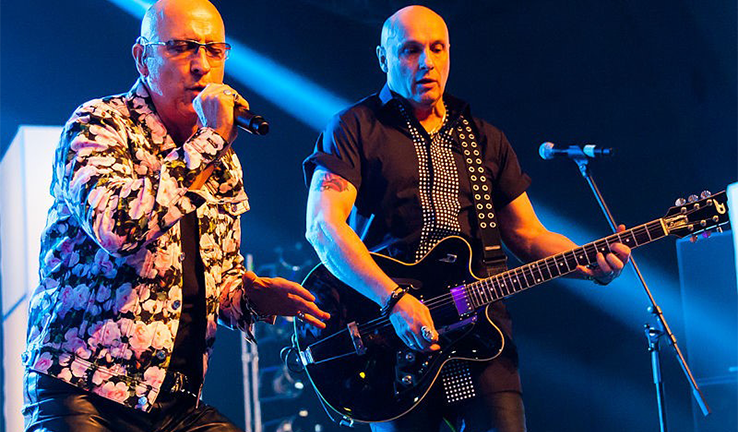 Photo of the band Right Said Fred at a concert. Photo of the band Right Said Fred at a concert.