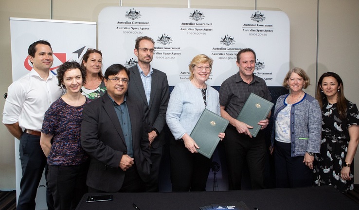 A group of nine people, two holding folders