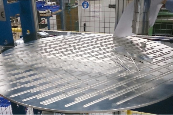 Large metallic dish with grooves, designed by Thermacore, located in a workshop cage