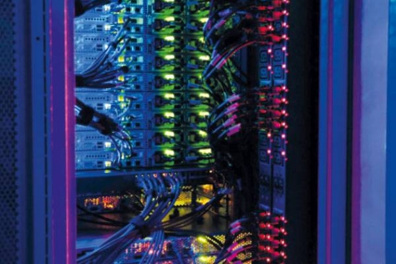 Stacked computer hardware in a case with different coloured lights and wiring