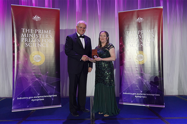 Photo of Mrs Sarah Finney on stage receiving her award.