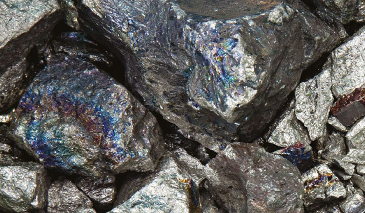 Photo shows metallic grey rocks, which have blue, streaked highlights on the surface