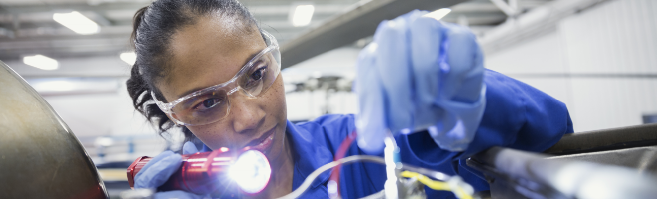 Woman wearing safety glasses and gloves working with wires in a laboratory