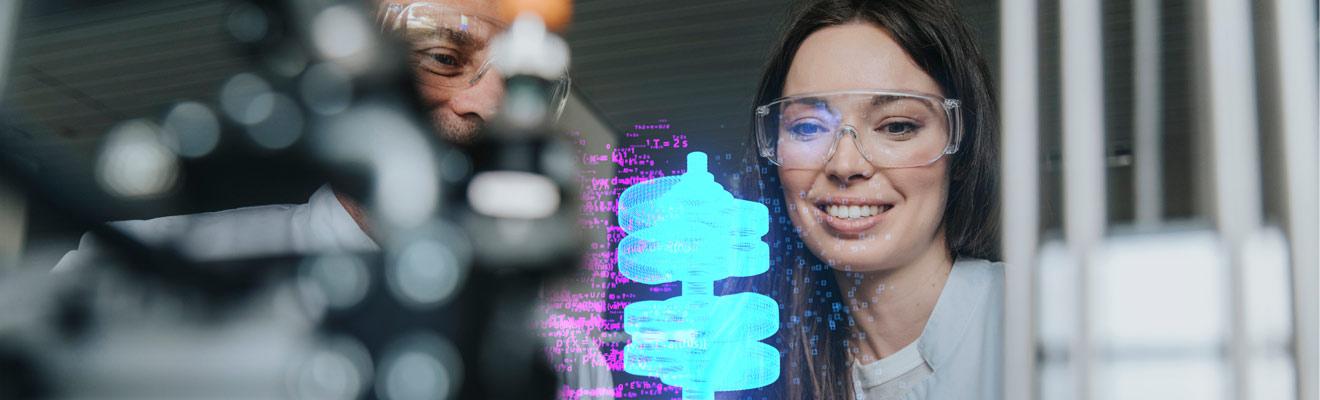 Photo of 2 scientists wearing lab goggles looking at a virtual coil