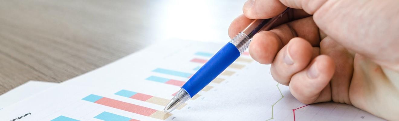A hand holding a pen over a report