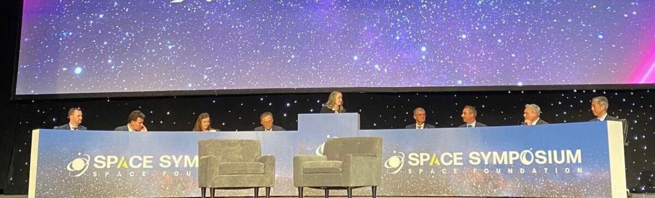 2023 space symposium stage with speakers sitting in a row.