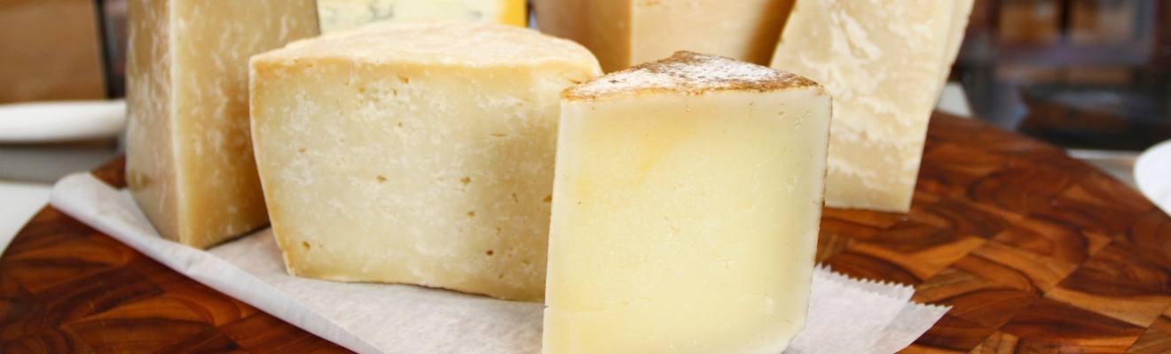 A board with 6 cheeses on it.