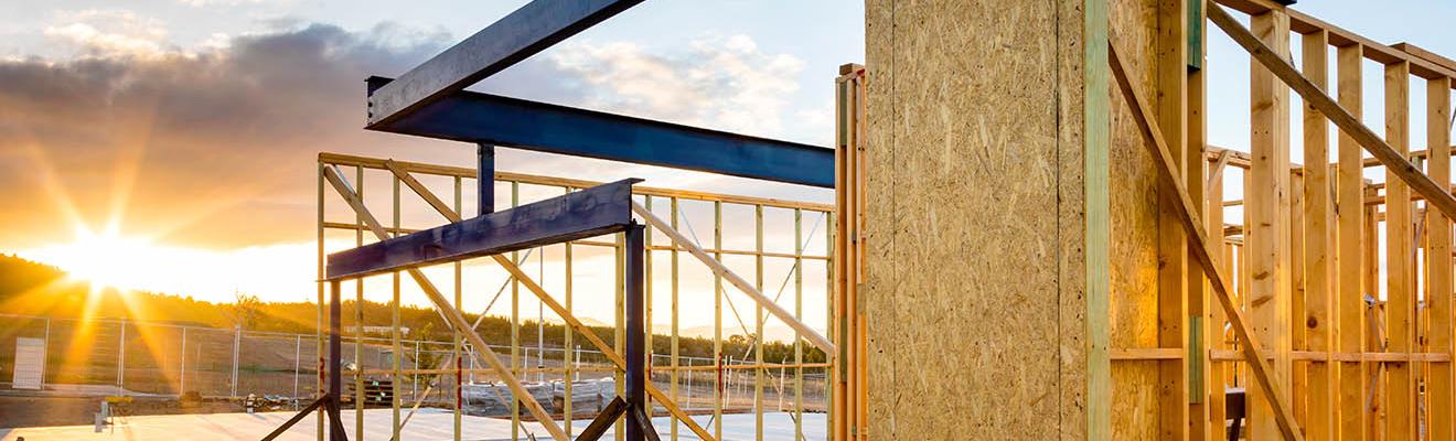 Timber frame of a new house being constructed, time of day is sunset