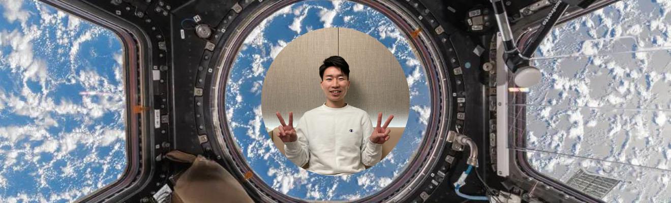 A young man smiling and displaying ‘peace fingers’.