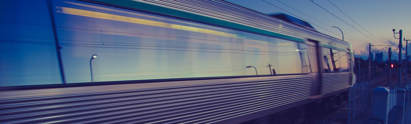 A passenger train in motion at dusk