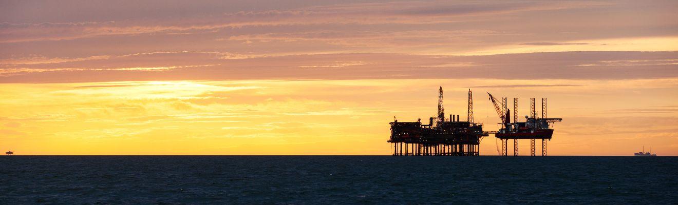 Silhouette of oil platform at sunset