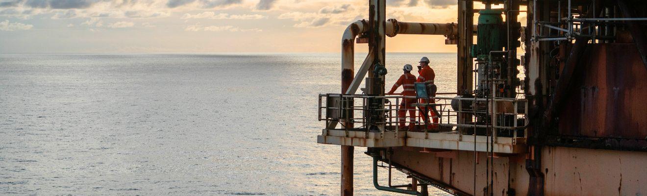 Offshore decommissioning workers standing on a ship, looking out to sea