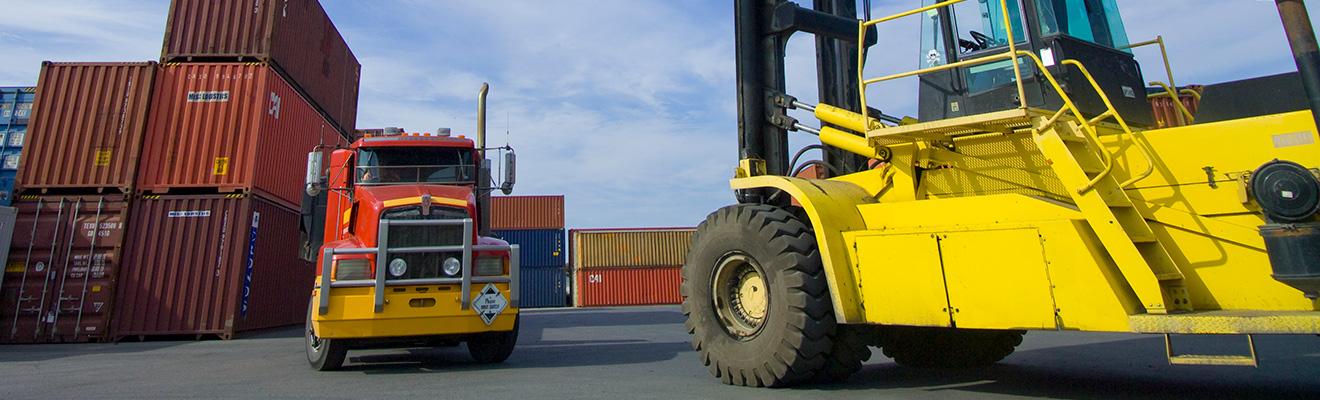 Image of a loaded container handler moving a shipping container.