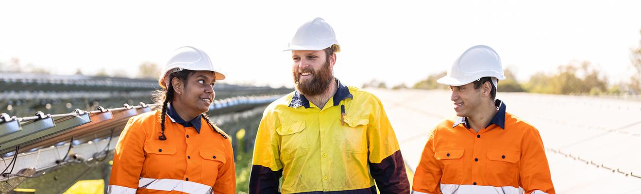 Three workers wearing protective, high visibility clothing
