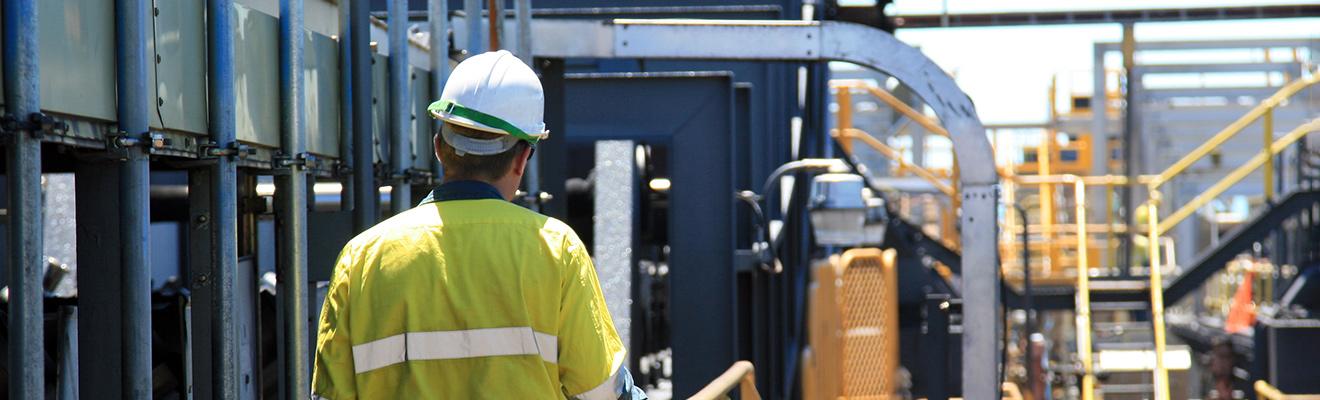 Photo of a construction worker wearing a safety uniform in industrial setting