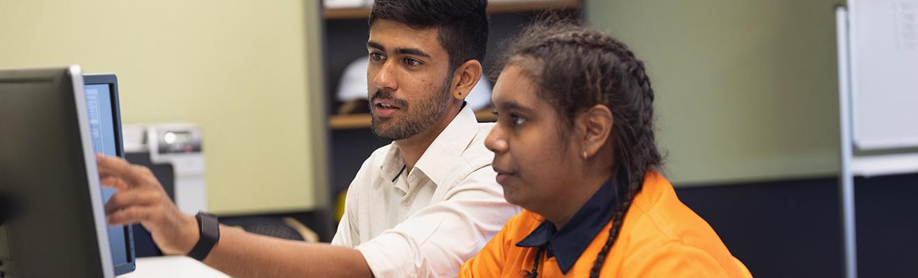 Engineer and apprentice working together in an office.