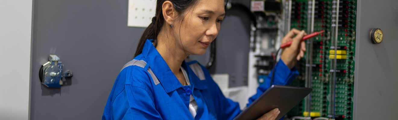 Photo of an IT technician using a digital tablet for work in a server room