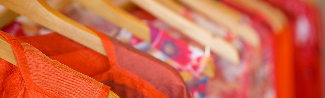 Close up image of textile clothing on clothing hangers.