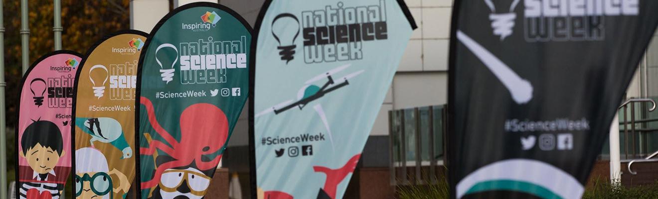 Flags showing various cartoons for National Science Week outside Questacon