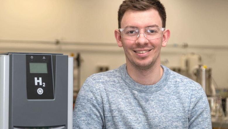 Photo of Dr Neil Robinson in his lab next to equipment