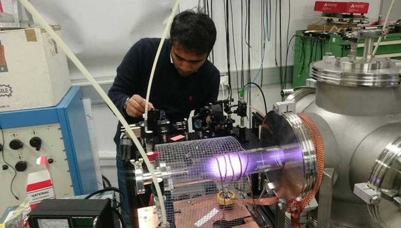 Photo of Rounak Manoharan in his lab operating equipment