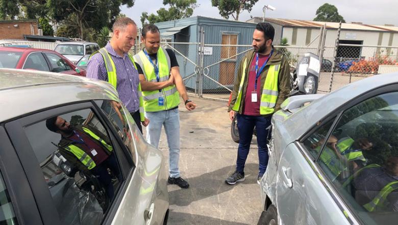 IAG employees check a damaged vehicle
