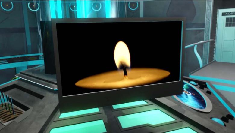 Screenshot from video showing a tea-light candle on a computer monitor