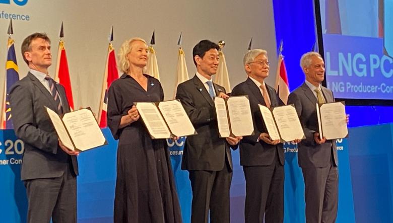 Photo of officials in a row with the signed agreements.