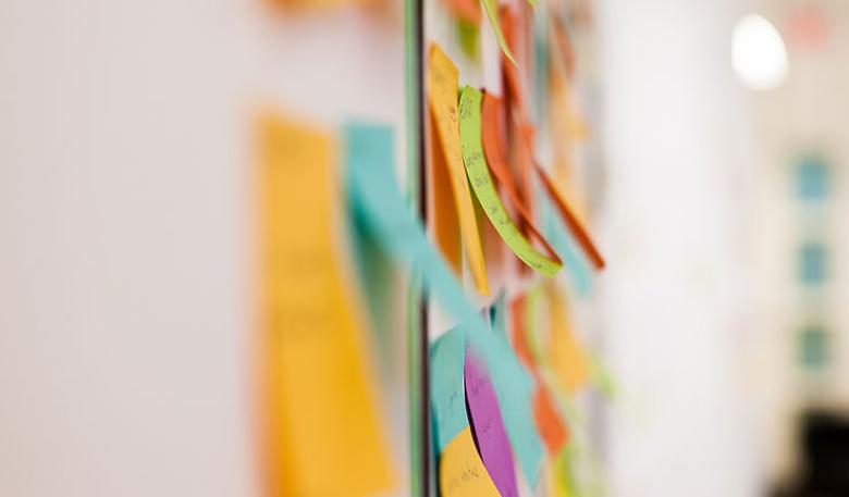 Photo of a wall of coloured post-it notes from one of our in-person trainings.