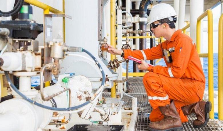 Photo of an offshore oil and gas worker operating equipment.