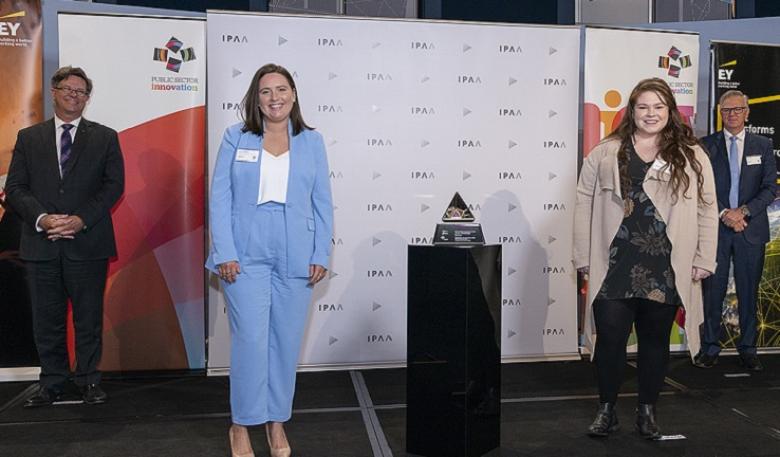 Two of the team from the Department of Agriculture, Water and the Environment receive a trophy