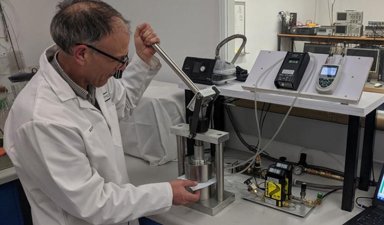 Photo of a man testing a face mask in a laboratory