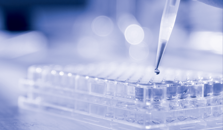 Lab technician injecting liquid into a microtiter plate