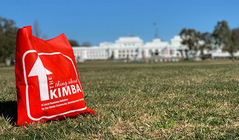 A red Kimba shopping bag on the lawns outside old Parliament House in Canberra