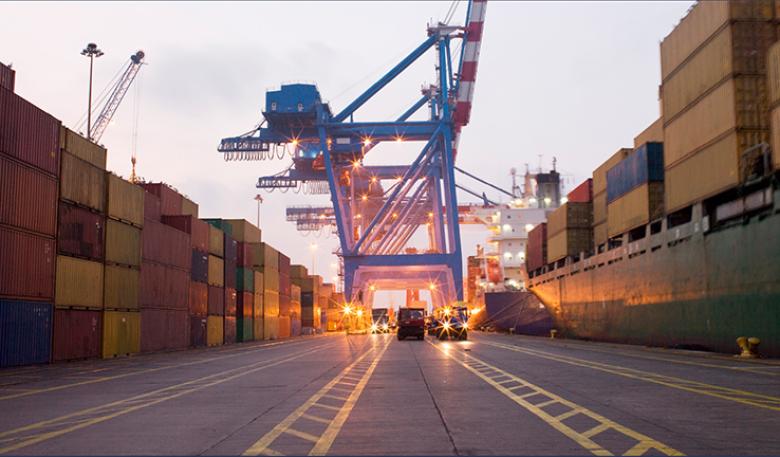 Photo of shipping containers and equipment on a dock.