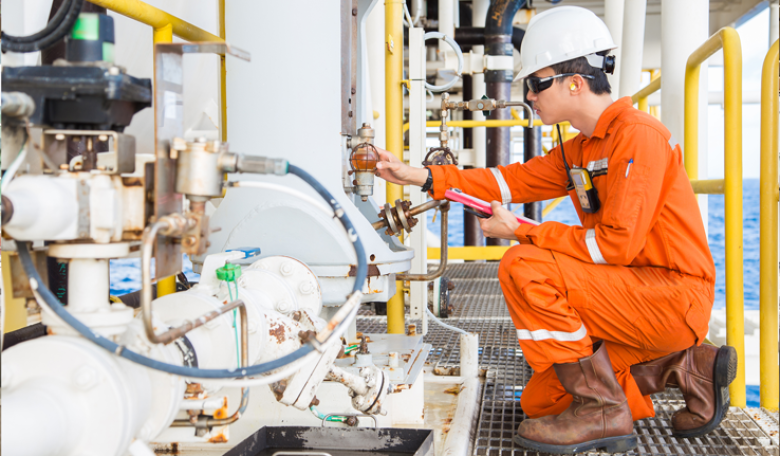 Photo of an offshore oil and gas worker operating equipment.