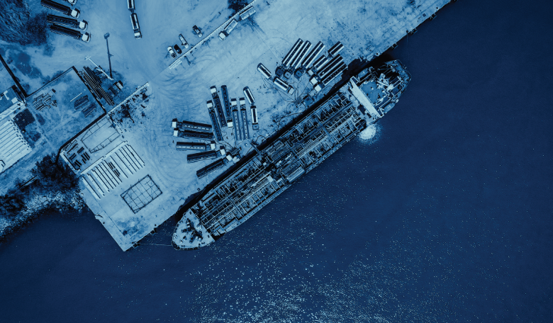Arial photo of shipping containers and a vessel at port.