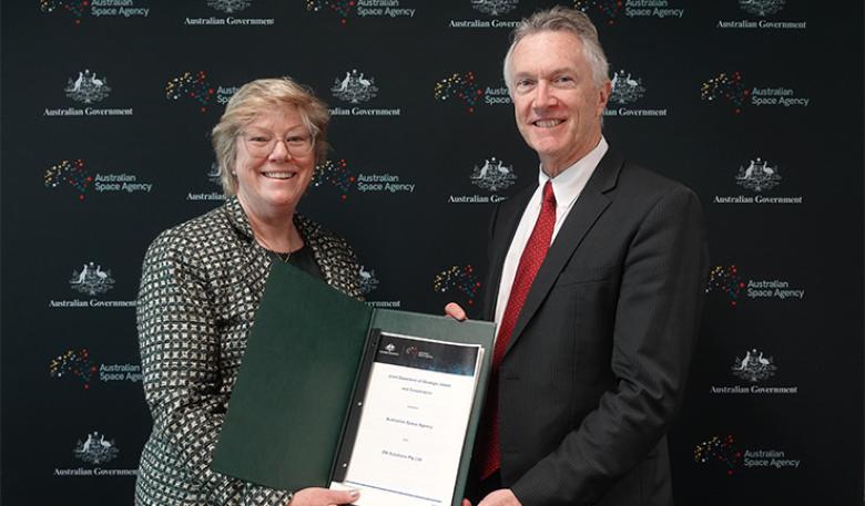 Photo of Australian Space Agency and EM Solutions leaders holding the signed agreement. Photo of Australian Space Agency and EM Solutions leaders holding the signed agreement.