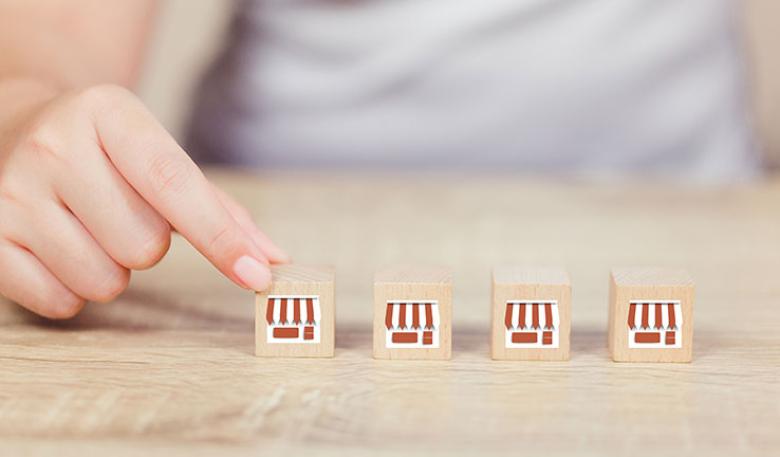 Four wooden blocks decorated to look like shops