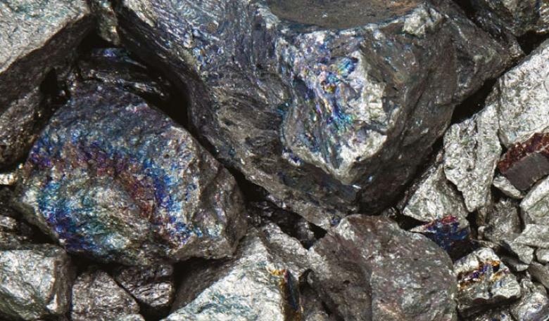 Photo shows metallic grey rocks, which have blue, streaked highlights on the surface