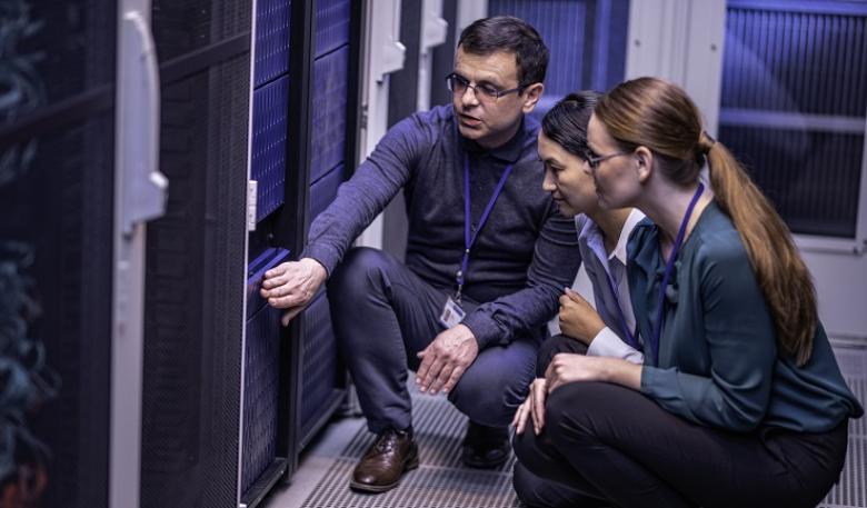 IT specialists examining a server in a data centre.