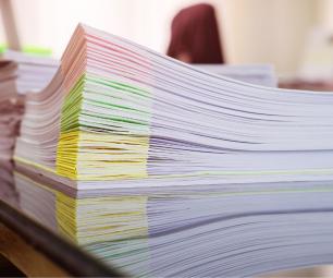 A stack of colour-coded documents on a desk