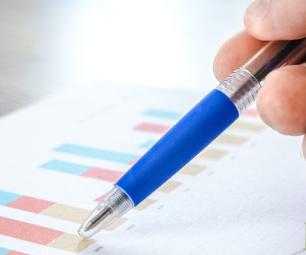 A hand holding a pen over a report