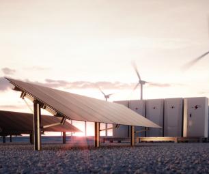 Solar panels in front of a wind farm